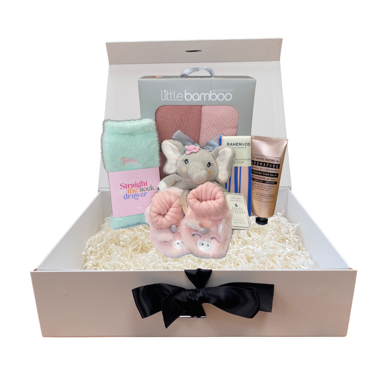 Baby girl gift set with plush toy, skincare products, booties and other items in a box.