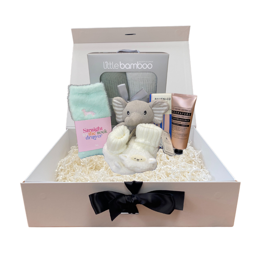 Baby gift box with baby items including a plush elephant, book, and lotion, branded 'little bamboo'.