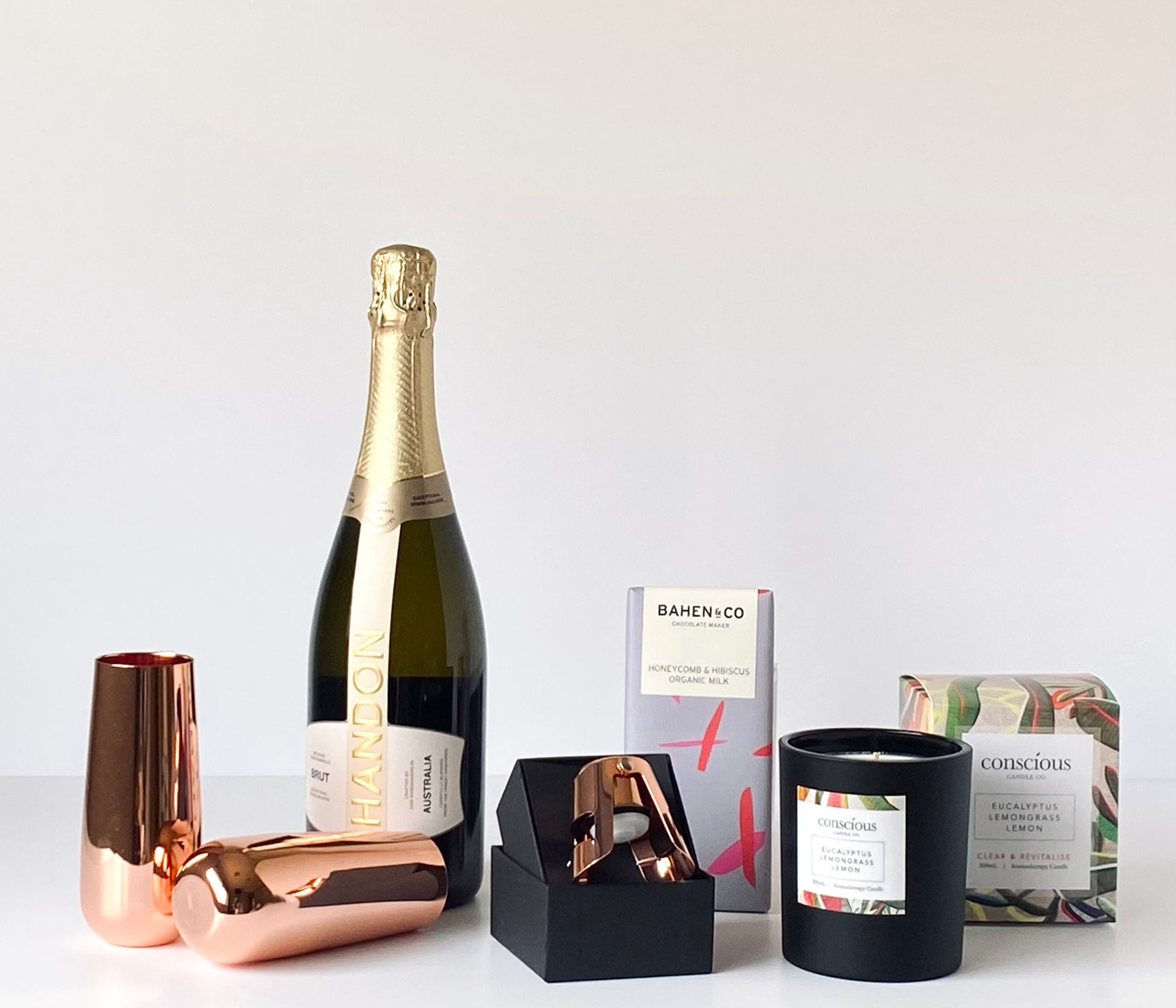 The Luxe Celebration contents - Chandon NV Brut, Clinq copper champagne flutes and stopper, Conscious Candle Co candle and Bahen & Co chocolate - Gift Bento